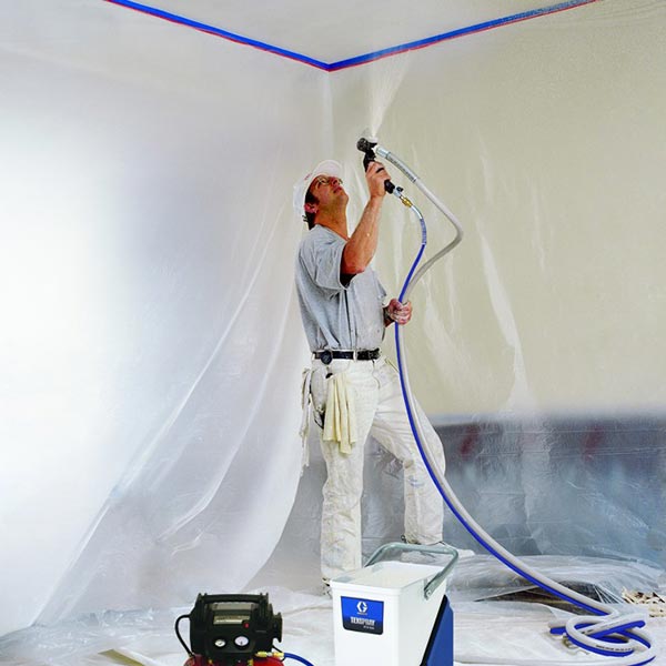 Professional painter carefully spraying an interior ceiling